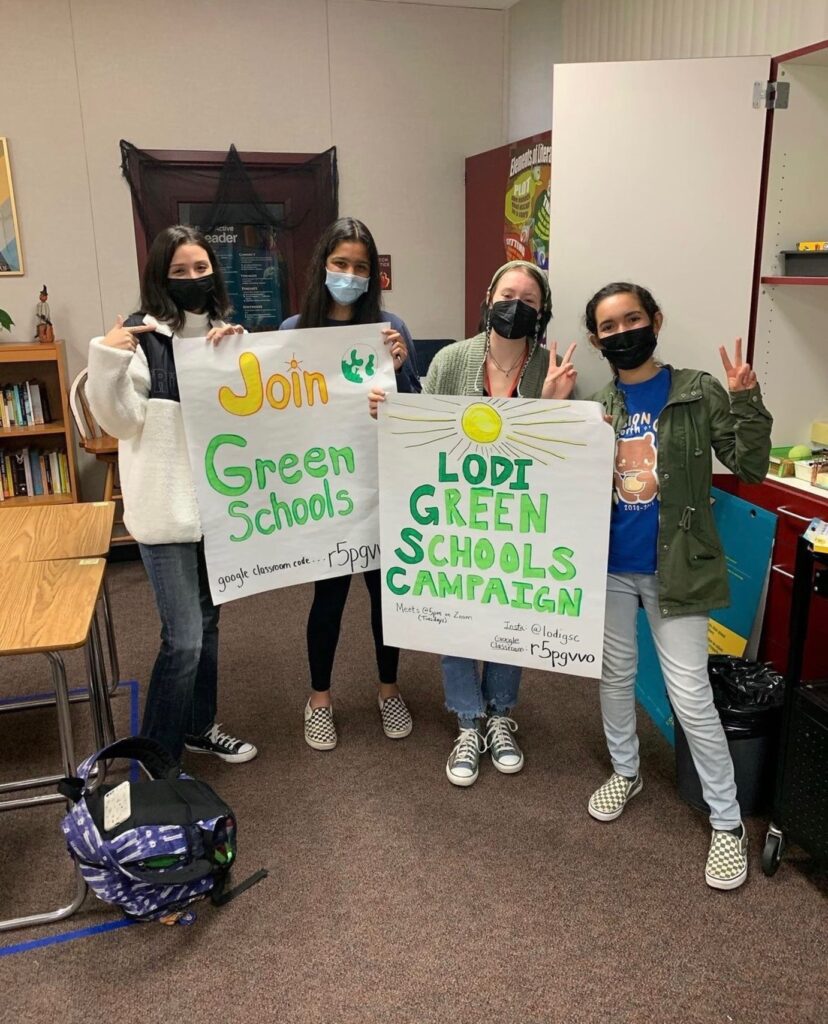 students with green school campaign signs