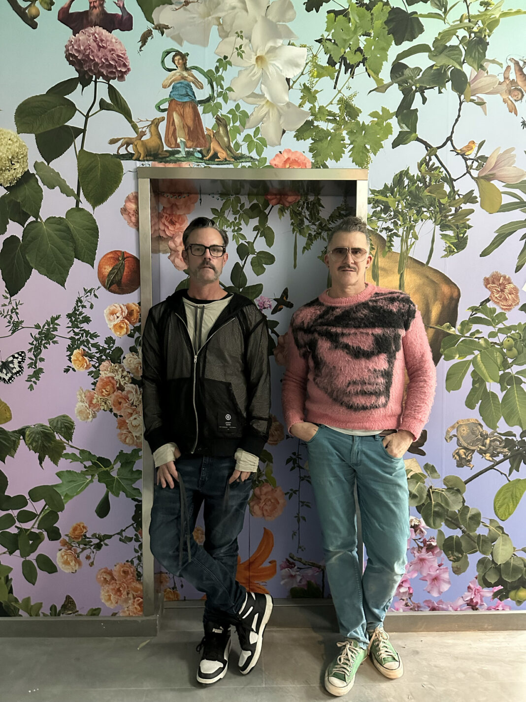 David Allen Burns and Austin Young stand in front of mural